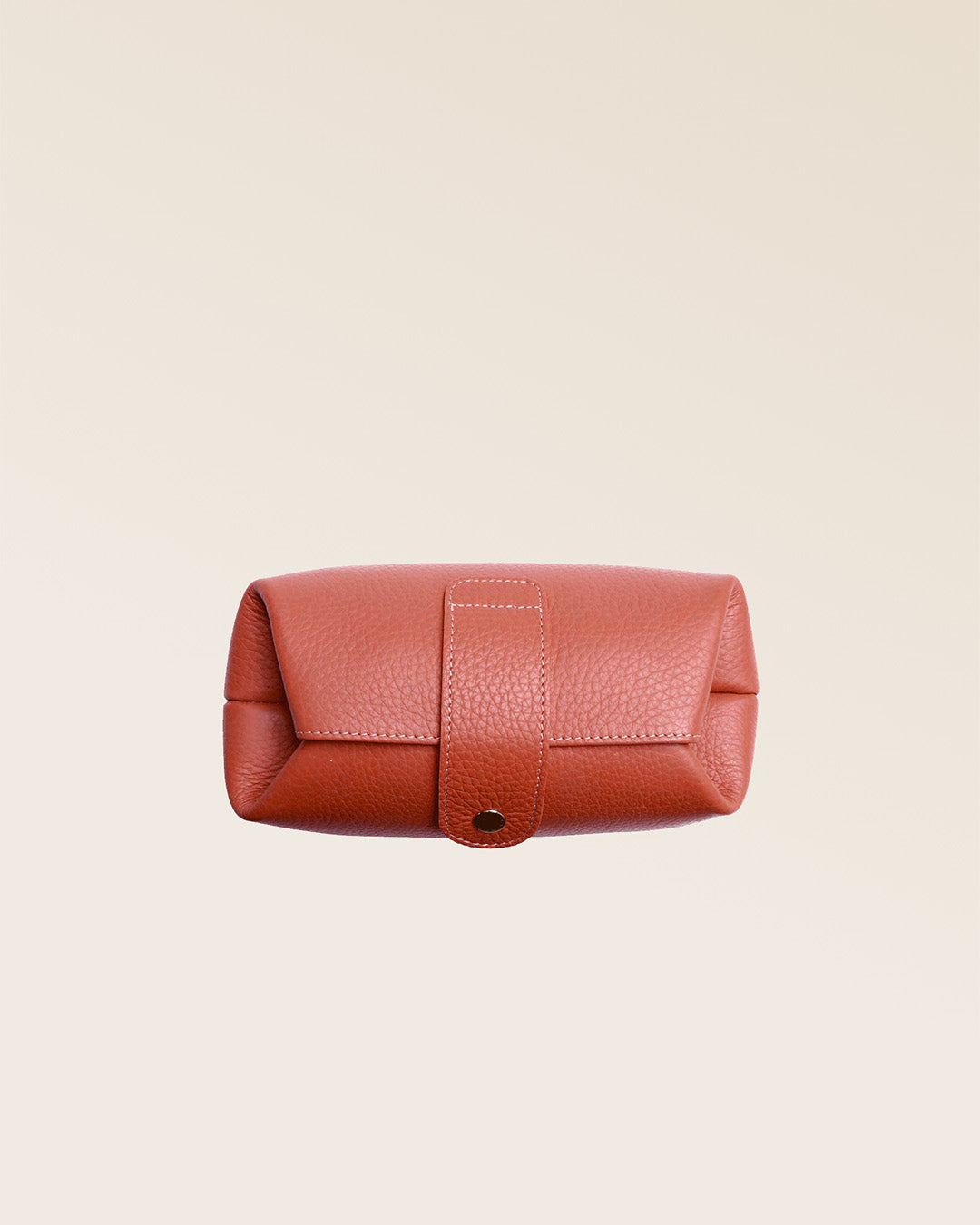 Notre trousse Vecchio Renouard en cuir façon vigogne terracotta vue du dessus en studio.